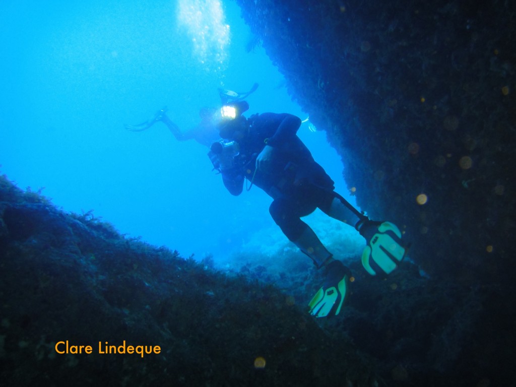 Tony taking footage as he swims backwards out of a cave